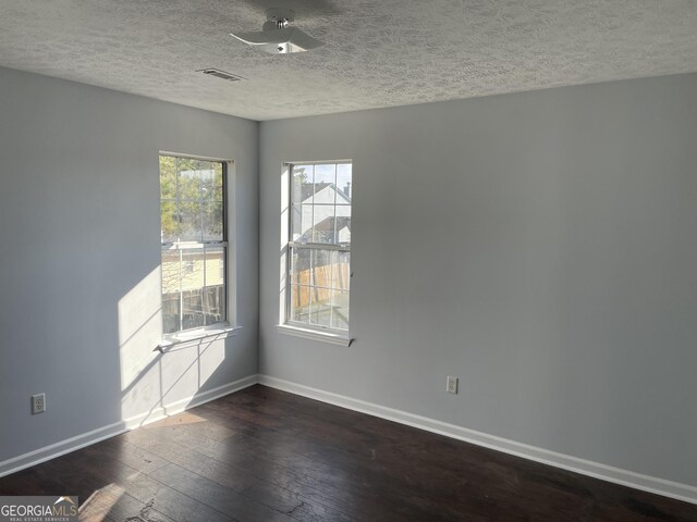 spare room with ceiling fan, dark wood-type flooring, and a textured ceiling