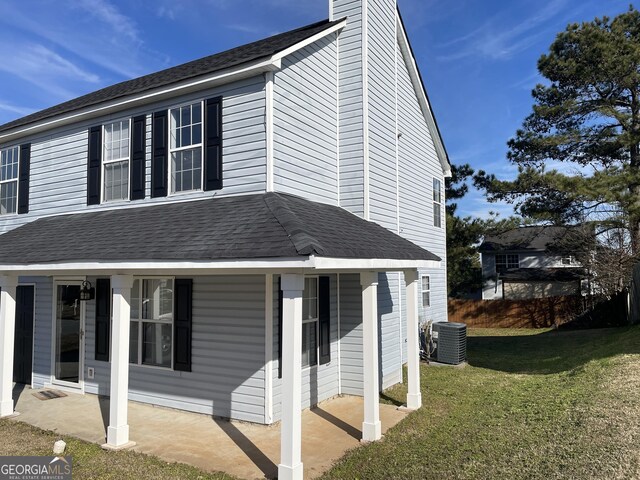 exterior space featuring central air condition unit and a lawn