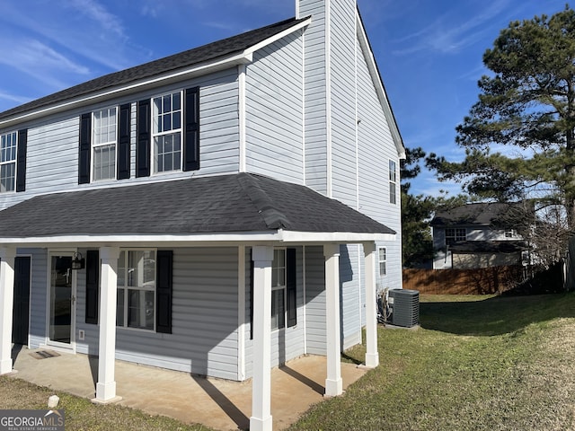 view of property exterior featuring a chimney, central AC unit, a lawn, and a patio area