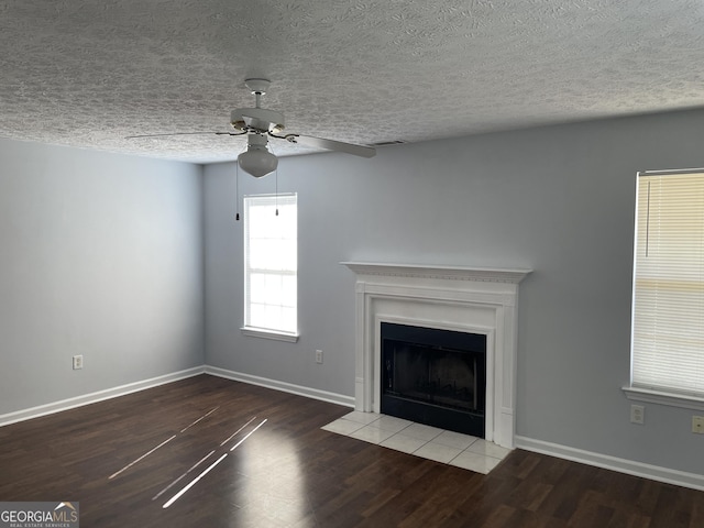 unfurnished living room with a fireplace with flush hearth, baseboards, and wood finished floors