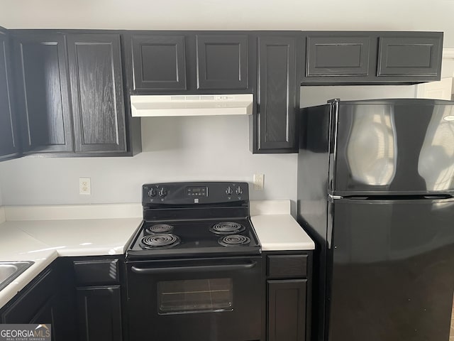 kitchen with a sink, black appliances, light countertops, and under cabinet range hood