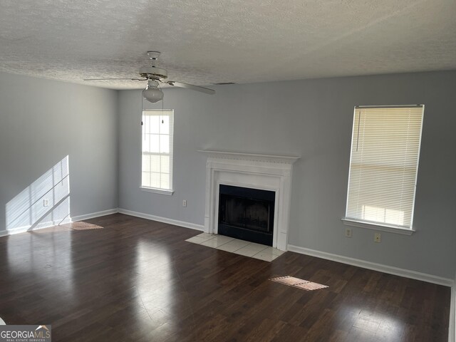 unfurnished living room featuring ceiling fan, wood-type flooring, and a textured ceiling