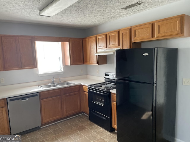 kitchen featuring under cabinet range hood, a sink, visible vents, light countertops, and black appliances