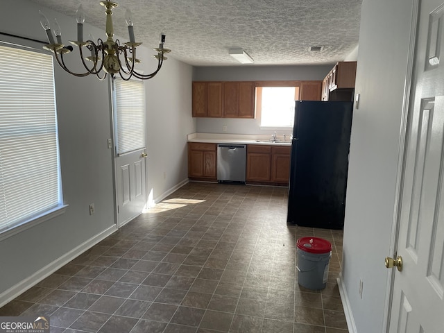 kitchen featuring a sink, baseboards, stainless steel dishwasher, freestanding refrigerator, and brown cabinets