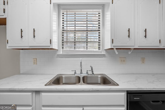 kitchen featuring backsplash, sink, black dishwasher, and white cabinetry