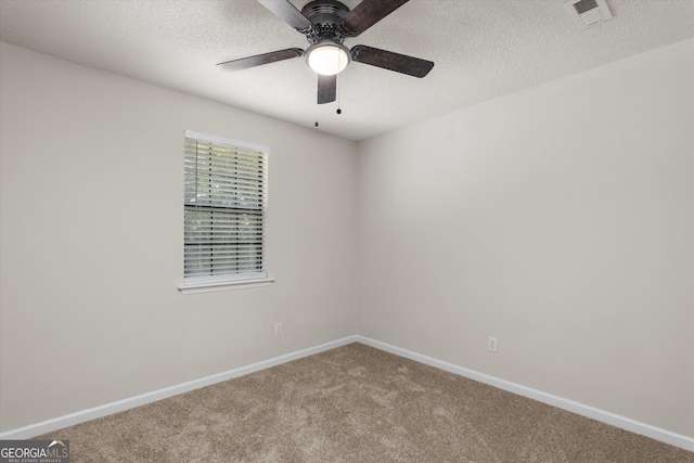 carpeted spare room featuring ceiling fan and a textured ceiling