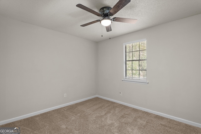 empty room with light carpet, ceiling fan, and a textured ceiling