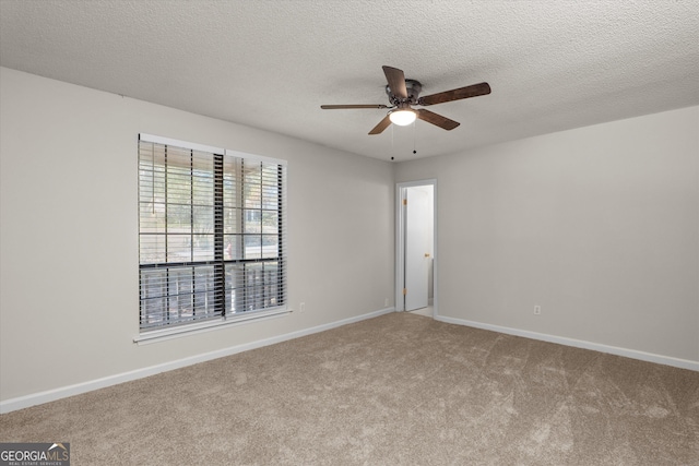 carpeted empty room with ceiling fan and a textured ceiling