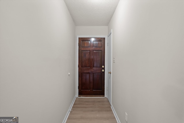 entryway with a textured ceiling and light hardwood / wood-style flooring