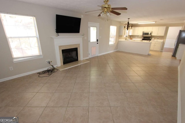 unfurnished living room featuring ceiling fan and light tile patterned floors