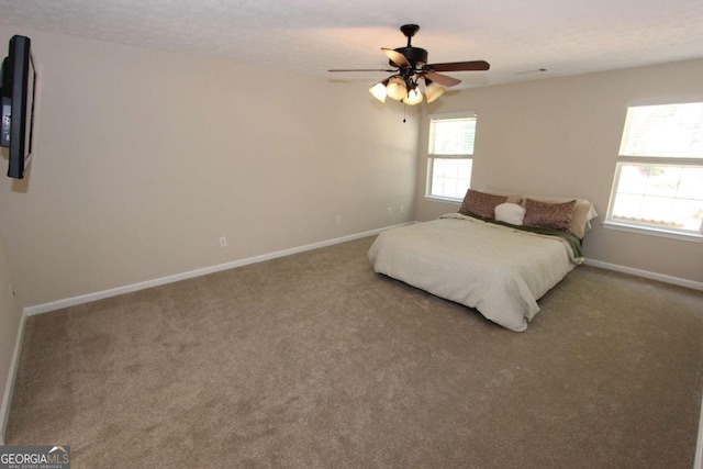 bedroom featuring ceiling fan, a textured ceiling, and carpet floors