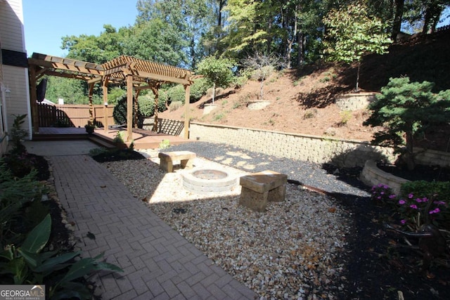 view of yard featuring a pergola, an outdoor fire pit, and a patio