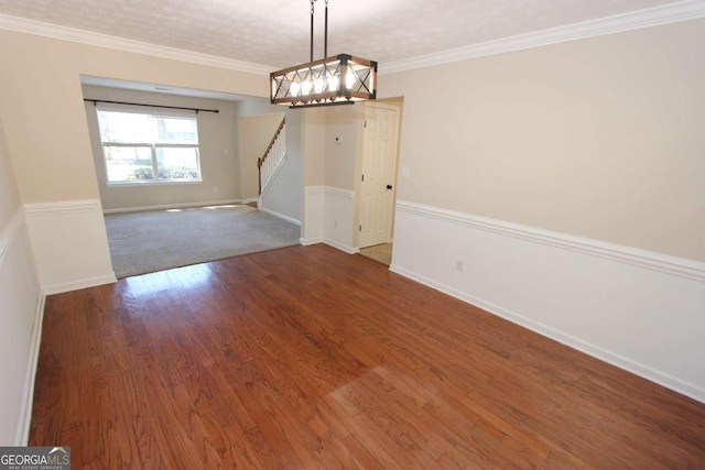 unfurnished dining area featuring wood-type flooring, an inviting chandelier, crown molding, and a textured ceiling