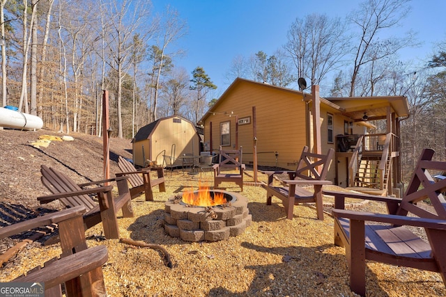 view of yard with stairs, an outbuilding, a shed, and an outdoor fire pit