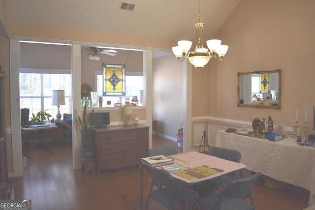 dining space featuring vaulted ceiling, ceiling fan with notable chandelier, wood finished floors, and visible vents