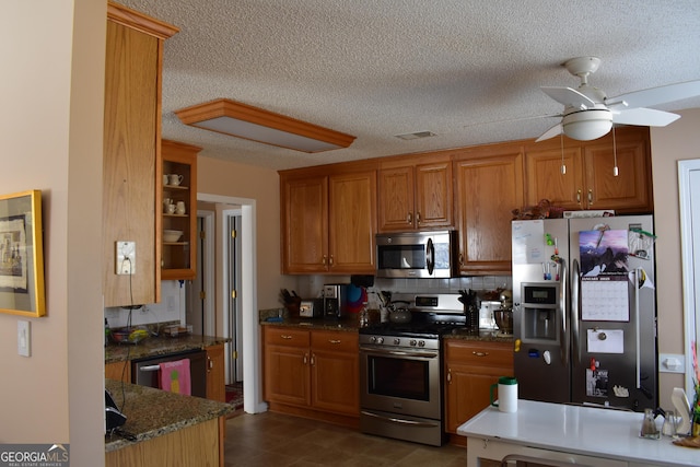 kitchen with ceiling fan, stainless steel appliances, brown cabinetry, and decorative backsplash