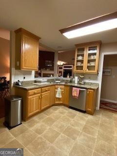 kitchen with glass insert cabinets, vaulted ceiling, and stainless steel dishwasher