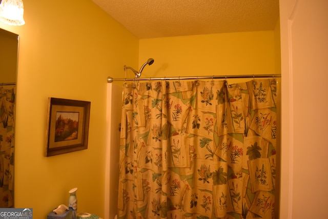 bathroom featuring a textured ceiling and a shower with shower curtain