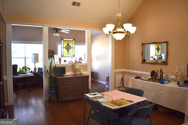 dining area featuring dark wood-style floors, visible vents, vaulted ceiling, and ceiling fan with notable chandelier