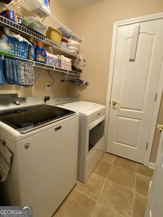 laundry area featuring laundry area, a textured ceiling, and washing machine and clothes dryer