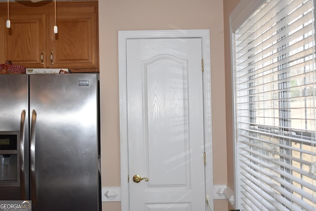 kitchen featuring stainless steel fridge and brown cabinets