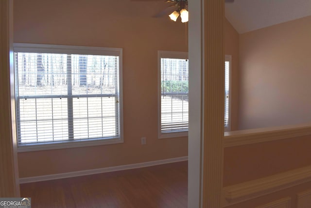 unfurnished room featuring ceiling fan, vaulted ceiling, baseboards, and wood finished floors