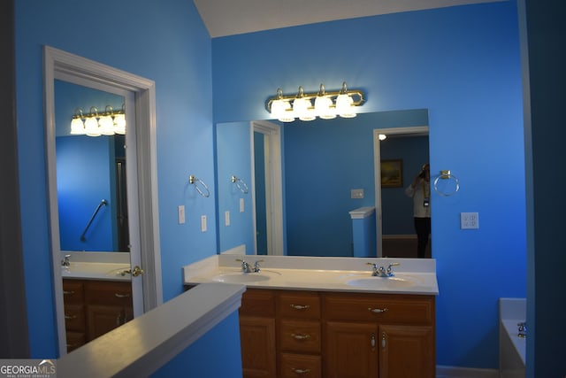 full bath featuring double vanity, a sink, and a bathing tub