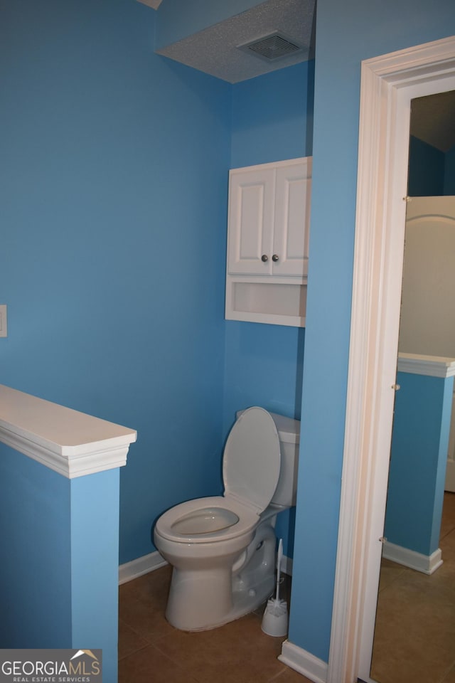 bathroom with baseboards, toilet, visible vents, and tile patterned floors