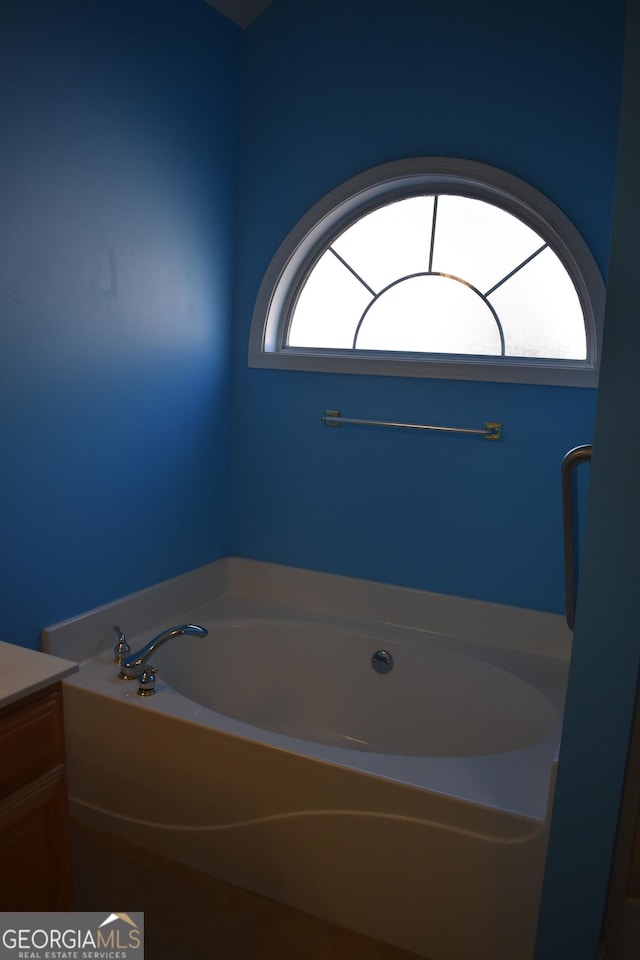 full bathroom with a garden tub and vanity