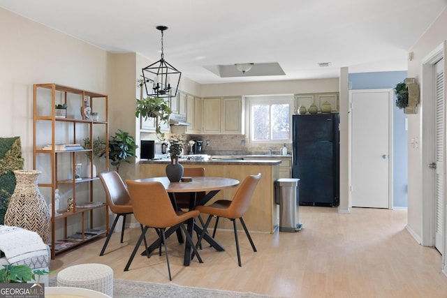 dining room with a notable chandelier and light wood-type flooring