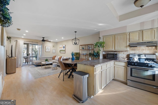 kitchen featuring kitchen peninsula, stainless steel gas range oven, ceiling fan, backsplash, and pendant lighting