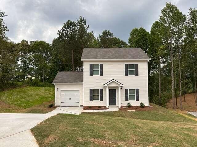 colonial house with a front lawn and a garage