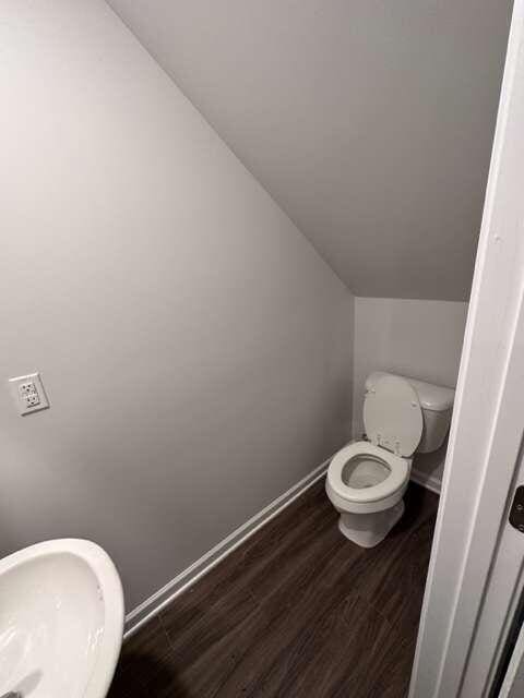 bathroom featuring lofted ceiling, wood-type flooring, and toilet