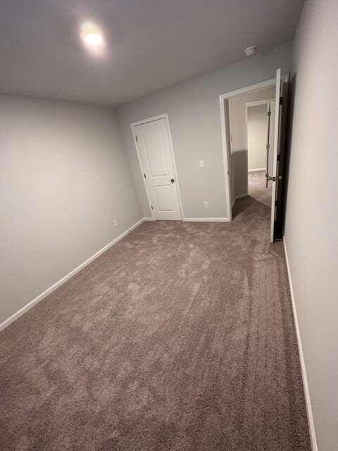 unfurnished bedroom with dark carpet