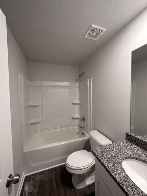 full bathroom featuring toilet, vanity, shower / tub combination, and hardwood / wood-style flooring