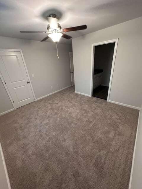 unfurnished bedroom with ceiling fan and carpet floors