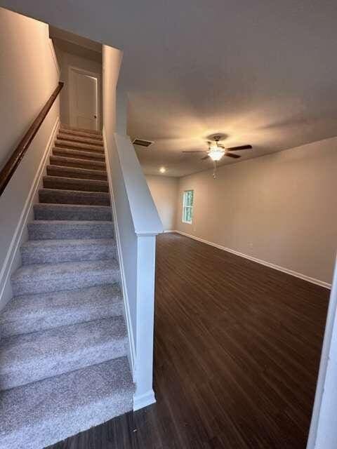 staircase featuring ceiling fan and hardwood / wood-style floors