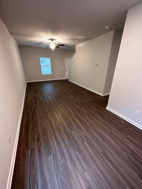 unfurnished room with ceiling fan and dark wood-type flooring