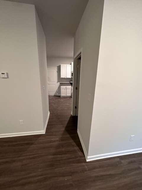 corridor with dark hardwood / wood-style flooring