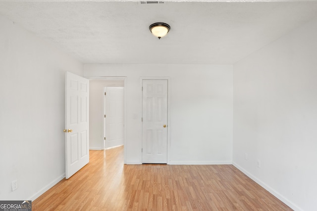 unfurnished room with light wood-type flooring