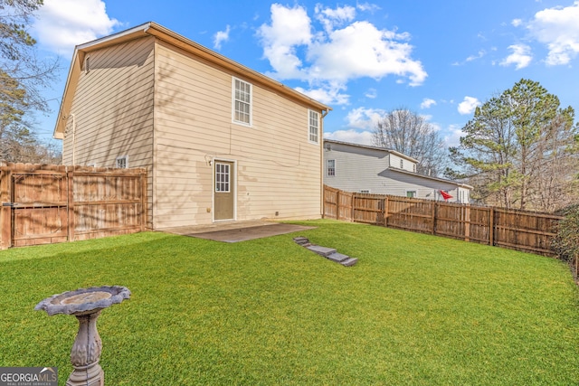 rear view of house featuring a yard and a patio