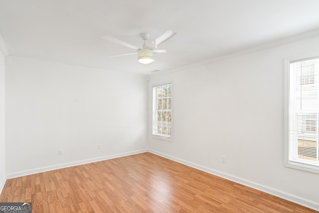 spare room featuring crown molding and light hardwood / wood-style flooring