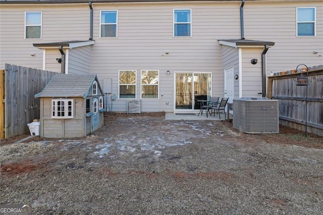 back of house featuring central AC, a storage shed, and a patio