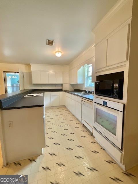 kitchen with white cabinets and white appliances