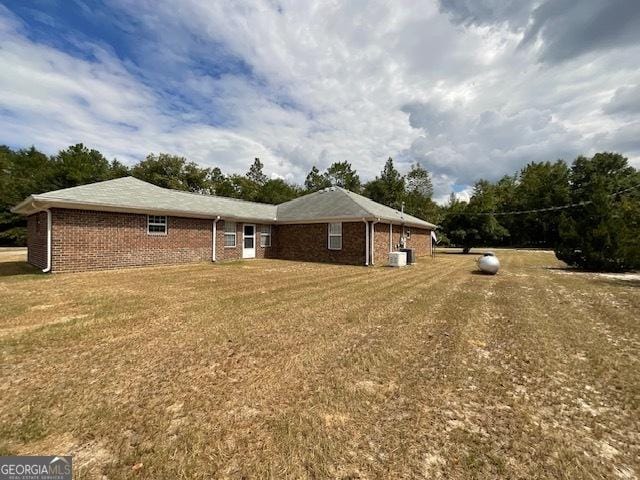 exterior space with cooling unit and a yard