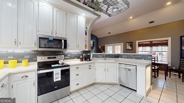 kitchen featuring kitchen peninsula, stainless steel appliances, and white cabinetry