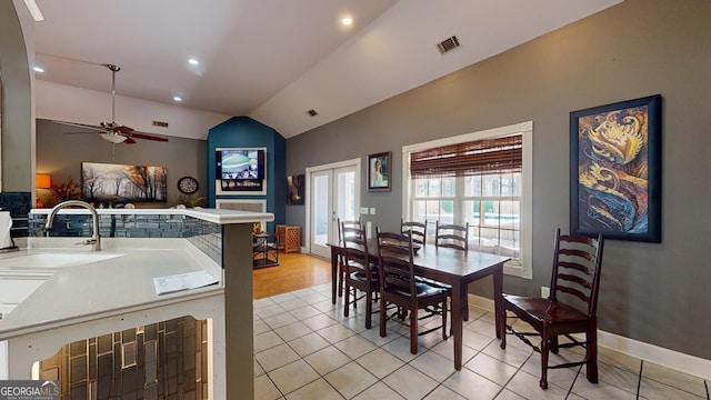 tiled dining room featuring ceiling fan, lofted ceiling, and sink