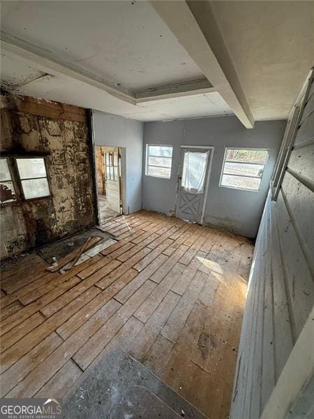 miscellaneous room featuring beam ceiling and light hardwood / wood-style flooring