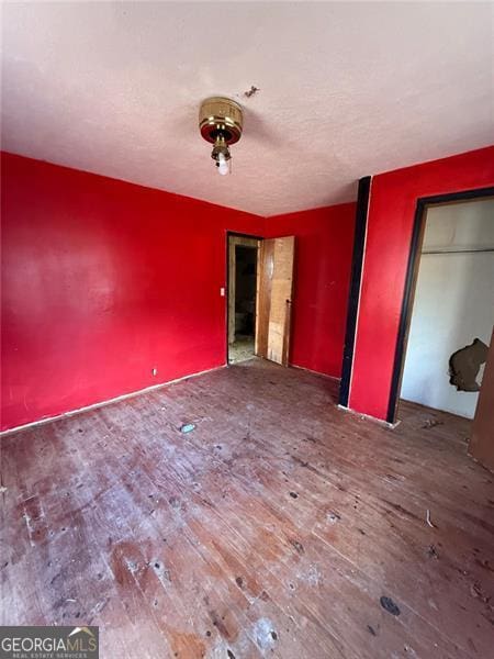 unfurnished bedroom featuring a closet and hardwood / wood-style floors