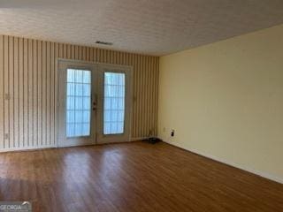 empty room featuring dark hardwood / wood-style flooring and french doors